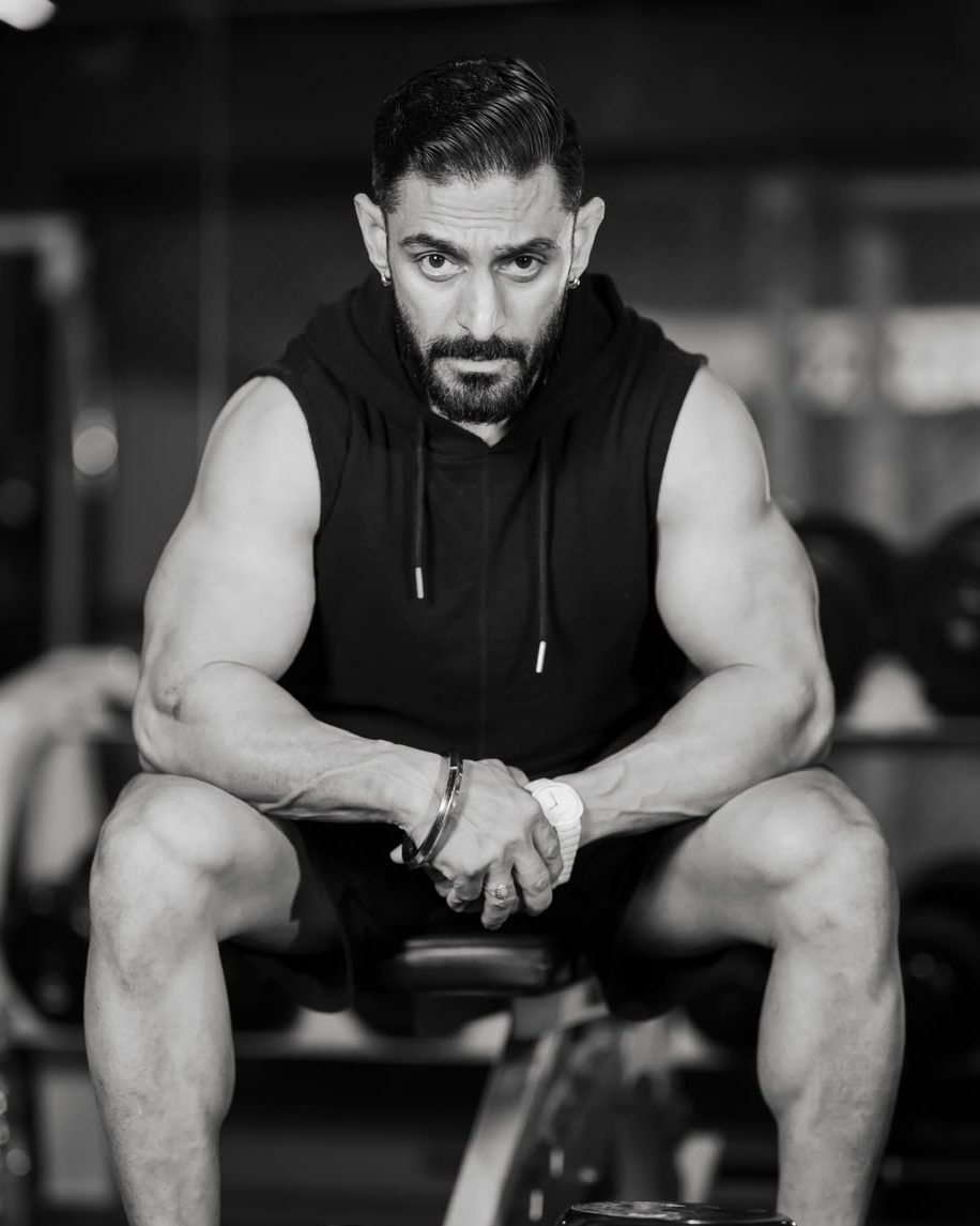 Saveen Menon in the gym, seated, forearms resting on his knees
